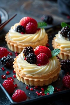 small desserts with berries and cream on a black plate