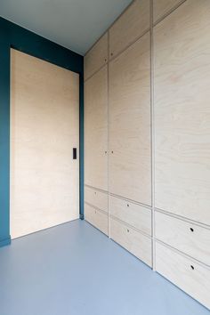 an empty room with blue walls and wood paneling on the wall is seen in this image