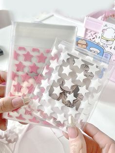 two clear cases with pink and white stars on the front, one has a cat sticker on it