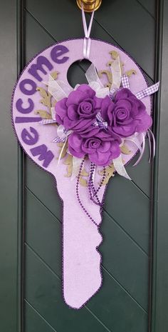 a door hanger decorated with purple flowers and the words welcome to me on it