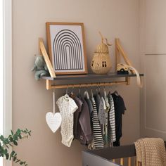 a baby's room with clothes and toys hanging on the wall