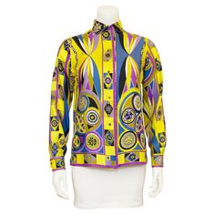 Vibrant printed Emilio Pucci silk shirt from the 1970s. Iconic Pucci abstract geometric and floral print in bright yellow, purple, blue and black. The upper back features a large butterfly. Fabric covered buttons and signed fabric. Classic Italian Riviera energy. Good vintage condition with some small signs of wear. Made in Italy. Fits like a US size 4. Interior Pucci tag has been removed. Sleeve 22" Shoulder 14" Bust 37" Waist 34" Hips 38" Length 26" Designer Multicolor Floral Print Shirt, Yellow Floral Print Silk Tops, Yellow Silk Top With Floral Print, Designer Multicolor Print Shirt For Spring, Designer Multicolor Printed Tops, Yellow Floral Print Silk Blouse, Yellow Silk Blouse With Floral Print, Multicolor Printed Silk Shirt, Designer Multicolor Graphic Print Blouse