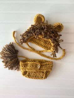 two crocheted hats with pom - poms on them