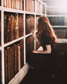 a woman sitting on a chair in front of a book shelf filled with lots of books