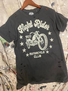 an old motorcycle club shirt hanging on a wooden hanger