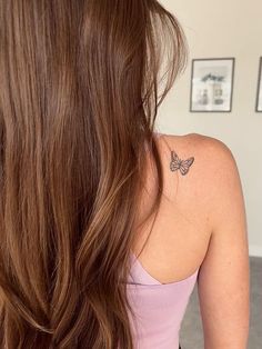 a woman with a butterfly tattoo on her upper arm and lower back half of her body