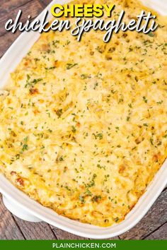 cheesy chicken spaghetti in a white casserole dish on a wooden table