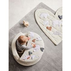 a baby is playing with his toys on the floor in front of two heart shaped rugs