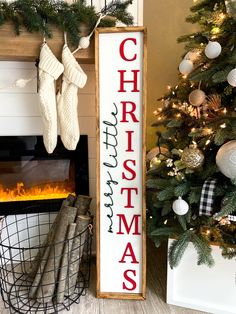 a christmas sign sitting next to a fire place