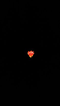 a red heart shaped object in the middle of a dark sky with no light on it