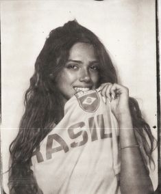 a black and white photo of a woman with long hair wearing a tshirt