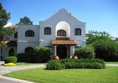 a large white house sitting on top of a lush green field