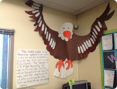 an eagle paper cutout on the wall above a bulletin board in a school classroom