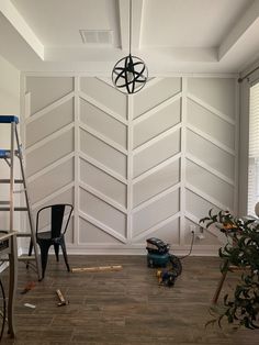 a room that has been painted white with wood paneling on the walls and floor