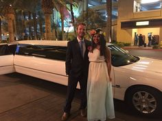 a man and woman standing in front of a limo