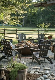 an outdoor fire pit surrounded by chairs and tables in the middle of a gravel area