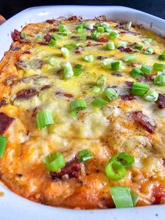 a casserole dish with green onions and cheese on it, ready to be eaten