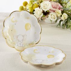 two plates with elephants on them and flowers in the background