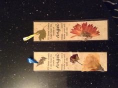 two bookmarks with flowers on them sitting on a counter top next to each other