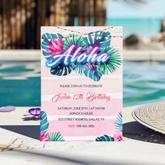 an aloha birthday party is set up by the pool with flowers and palm leaves