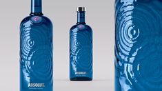 two blue bottles are shown next to each other on a gray background with swirl designs