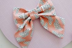 an orange and white bow on top of a pink plate