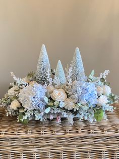 a basket filled with flowers and trees on top of a table