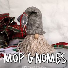 a knitted gnome is sitting next to presents and the words mop gnomes