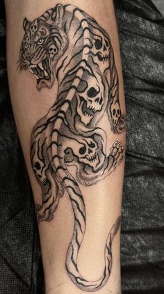 a man with a tiger and skull tattoo on his leg is shown in this photo