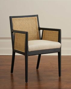 a wicker chair sitting on top of a hard wood floor next to a wall