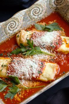 two ravioli stuffed with parmesan cheese and herbs in a dish on a table