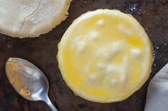 an uncooked pastry sitting on top of a table next to two spoons