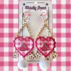 Elevate your accessory game with these charming pink heart-shaped earrings featuring a delightful gingham print adorned with sweet strawberries. Dangling from each earring is a white pom-pom charm, complemented by delicate white flower charms for a playful and feminine touch. Embrace a touch of whimsy and style with this delightful pair. 🍓Materials: Shrink plastic with a glossy and glittery resin coating. Backings are blank white. Earring hooks are 24k gold plated stainless steel. 🍓Lightweight Cute Earrings With Dangling Charms For Gifts, Playful Pink Earrings For Valentine's Day, Cute Pink Dangle Heart Earrings, Playful Pink Heart Earrings For Gift, Playful Pink Heart Earrings As Gift, Pink Kawaii Earrings For Valentine's Day, Pink Kawaii Heart Earrings For Valentine's Day, Kawaii Pink Earrings For Valentine's Day, Cute Pink Heart Charm Earrings