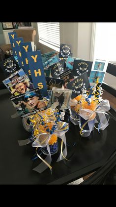 the table is set up with books and decorations for an event or graduation party in blue, yellow and white