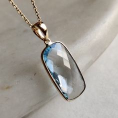 This stunning Pendant is set in 14k Solid Yellow Gold with Natural Sky Blue Topaz with utmost precision. It is a unique gemstone Pendant for nearly every occasion and is completely hassle-free jewelry. ITEM DETAILS: * GEM: Sky Blue Topaz * GEM SIZE: 10x20mm * GEM SHAPE: Cushion Rectangle * Gem weight: 13.02 carats * Gold Purity: 14KT (58.33% approx.) * Gold Weight: 1.10 gram * Total Weight of the Pendant: 3.70 gram The Gold purity is guaranteed and it comes with authentic 14KT gold hallmark. Since my items are handmade, they are absolutely nickel and lead free. CUSTOMIZATION: * Gemstone customization is available and it can be substituted with a gem of your choice. Kindly message me for the same. PACKAGING * The Pendant comes with layers of safe and secure wrapping along with Free handmade Blue Topaz Gemstones With Gemstone Accents For Gift, Blue Topaz Faceted Jewelry, Faceted Blue Topaz Jewelry, Cloudless Sky, Gold Skies, Handmade Jewelry Box, Blue Topaz Pendant, Topaz Pendant, Bezel Pendant