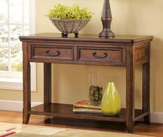 a wooden table with two drawers and a vase on top