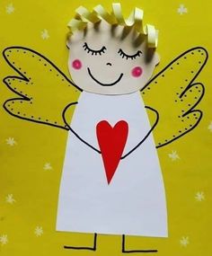 a paper angel holding a heart on a yellow background