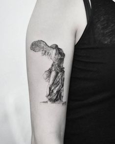 a black and white photo of a woman's arm with an angel tattoo on it