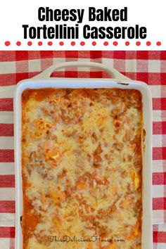 cheesy baked tortellini casserole in a white dish on a red and white checkered tablecloth