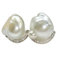 14 Karat White Gold South Sea Baroque Pearl Diamond Earrings. Each earring features a South Sea Baroque pearl and a semi-curve of channel-set baguettes and four bezel-set round diamonds. The four round diamonds measure 1.5mm each/0.015ct for a total carat weight of 0.16tcw. One pearl has a more blueish tone than the other, however they both have good luster. The earrings measure approximately 18mm high x 10.5mm wide and include a push back. The total gold weight of the earrings is 10.18 grams. Pearl Diamond Earrings, Pearl And Diamond Earrings, South Seas, Pearl Diamond, Stone Design, Gold Pearl, Baroque Pearls, Silver Heart, Jewelry Earrings Studs