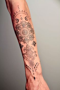 a person's arm with a tattoo on it and an intricate design in the middle