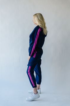 We couldn’t keep something this good to ourselves. These jogger style windbreaker pants our exclusive to us + come in inclusive sizing. They have a thick + flexible waistband with pink stripe down the sides of the legs. Pair with The Dua Windbreaker to make it a set. Details Model is wearing a small self/lining: 100% cotton Fabric Care Guide Here Sizing & Fit Measurements are approximate and taken while laying flat across the front. Not doubled. x-small: waist = 12"; length = 38"; inseam = 27" s Pink Spring Joggers For Jogging, Pink Athleisure Tracksuit For Jogging, Navy Sporty Joggers For Loungewear, Navy Sporty Bottoms For Spring, Sporty Navy Joggers For Loungewear, Spring Joggers With Side Stripes For Jogging, Pink Spring Joggers, Sporty Stretch Tracksuit For Spring, Sporty Spring Tracksuit With Stretch