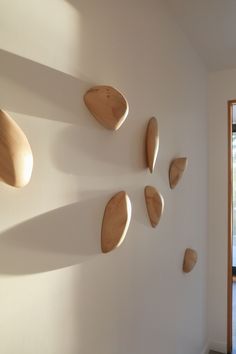 some wooden spoons are hanging on the wall next to a door and window in a white room