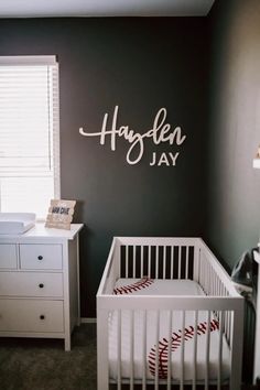 a baby's room with a baseball theme on the wall and a crib