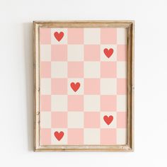 a frame with hearts on it hanging on the wall