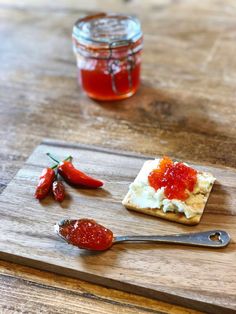 a wooden cutting board topped with food next to a jar of ketchup