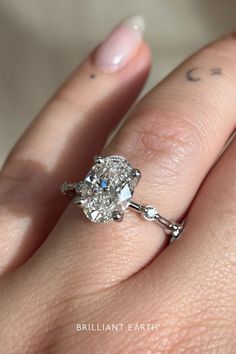 a woman's hand with a diamond ring on it