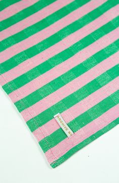 a pink and green striped cloth with a tag on it