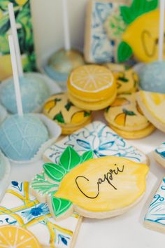 some cookies and lemons are sitting on a table with blue and yellow decorations around them