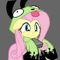 a pink and green pony with big eyes sitting on top of a pile of dirt